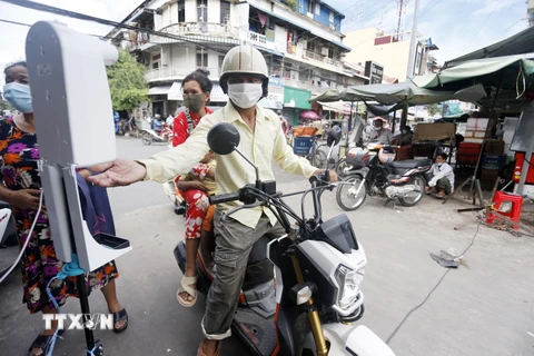 Người dân sát khuẩn tay phòng dịch COVID-19 tại một khu chợ ở Phnom Penh, Campuchia, ngày 11/10/2021. (Ảnh: THX/TTXVN)