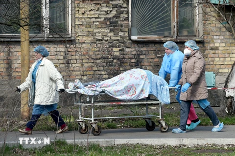 Nhân viên y tế chuyển thi thể bệnh nhân COVID-19 tại Kiev, Ukraine, ngày 9/4/2021. (Ảnh: AFP/TTXVN)