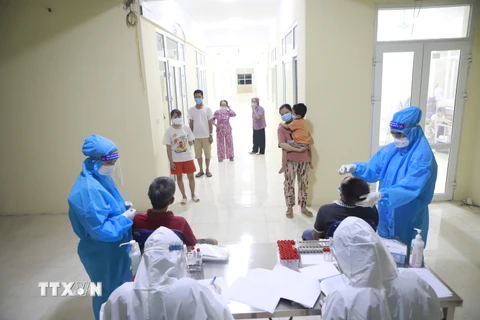 Lực lượng y tế tổ chức tổ chức xét nghiệm sàng lọc SARS-CoV-2 cho các trường hợp công dân cách ly tại Trung tâm đào tạo vận động viên Vĩnh Phúc. (Ảnh: Hoàng Hùng/TTXVN)