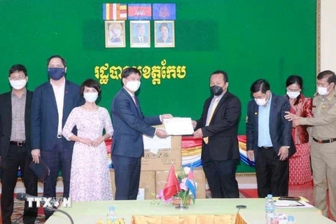 Tỉnh trưởng Kep Som Piseth (phải) nhận tượng trưng vật tư chống dịch COVID-19 của Quỹ hỗ trợ cộng đồng tại Campuchia. (Ảnh: Trần Long/TTXVN)