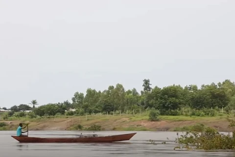Một người đàn ông băng qua sông Oti trên một chiếc canô. (Nguồn: africa.cgtn.com)