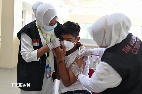 Nhân viên y tế tiêm vaccine phòng COVID-19 cho học sinh tại Banda Aceh, Indonesia, ngày 9/11/2021. (Ảnh: AFP/TTXVN)