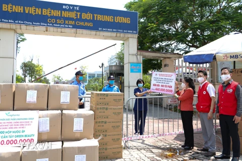 Trung ương Hội Chữ thập đỏ Việt Nam và Hội Chữ thập đỏ thành phố Hà Nội trao quà hỗ trợ công tác phòng, chống dịch COVID-19 tại Bệnh viện Nhiệt đới Trung ương cơ sở Kim Chung. (Ảnh: TTXVN phát)