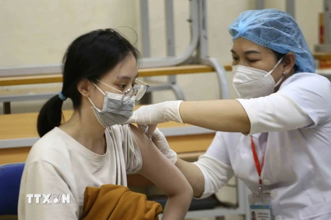 Học sinh lớp 9 trường THCS Thanh Quan, quận Hoàn Kiếm, Hà Nội được tiêm vaccine phòng COVID-19, chiều 27/11. (Ảnh: Tuấn Đức/TTXVN)