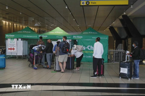 Hành khách xếp hàng chờ xét nghiệm COVID-19 tại sân bay ở Johannesburg, Nam Phi, ngày 27/11/2021. (Ảnh: AFP/TTXVN)