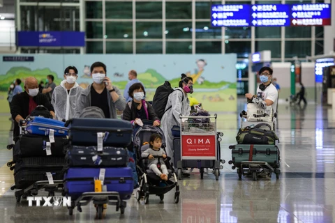 Hành khách tại sân bay quốc tế Hong Kong, Trung Quốc. (Ảnh: AFP/TTXVN)