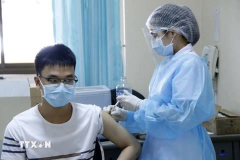 Một học sinh trên 12 tuổi đang được nhân viên tiêm tại bệnh viện Setthathirath, thủ đô Vientiane. (Ảnh: Phạm Kiên/TTXVN)