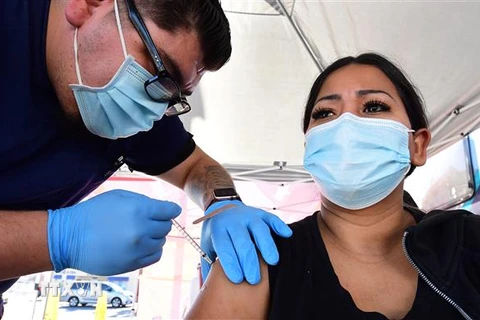 Nhân viên y tế tiêm vaccine ngừa COVID-19 cho người dân tại Rosemead, California, Mỹ, ngày 29/11/2021. (Ảnh: AFP/TTXVN)