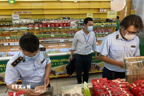 Các kiểm soát viên thị trường của Cục Quản lý thị trường TP Hồ Chí Minh kiểm tra nhiều nội dung tại cửa hàng Bách Hóa Xanh. (Ảnh: Thành Chung/TTXVN)