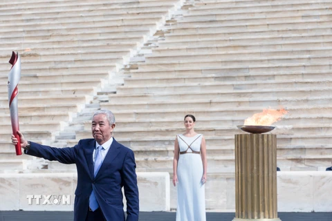 Phó Chủ tịch IOC Trung Quốc Yu Zaiqing nhận ngọn đuốc Olympic tại sân vận động Panathenaic ở Athens (Hy Lạp) ngày 19/10/2021. (Ảnh: THX/TTXVN)
