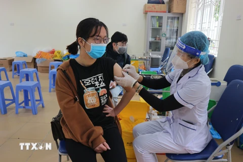Nhân viên y tế tiêm phòng vắc xin cho người dân trên địa bàn quận Hai Bà Trưng. (Ảnh Mạnh Khánh/TTXVN)
