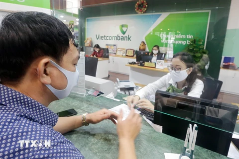 Khách hàng giao dịch tại Hội sở chính Vietcombank, Hà Nội. (Ảnh: Trần Việt/TTXVN)