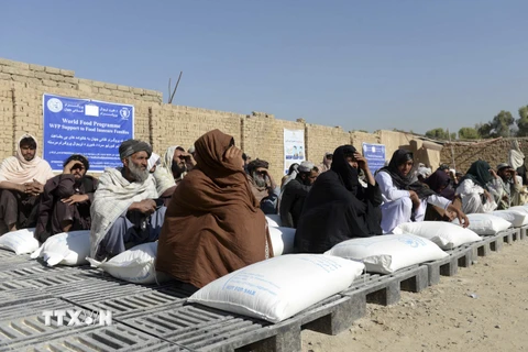 Người dân Afghanistan nhận lương thực viện trợ từ Chương trình Lương thực thế giới, tại Kandahar, ngày 19/10/2021. (Ảnh: AFP/TTXVN)