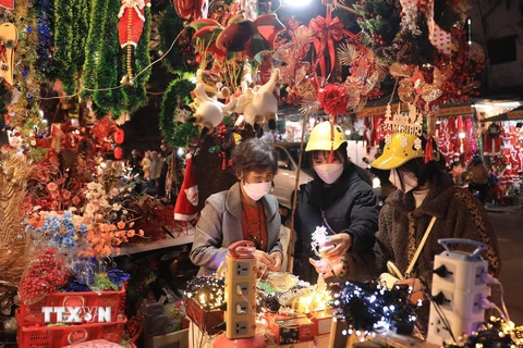 Người dân mua sắm đồ Giáng sinh 2021 trên phố Hàng Mã. (Ảnh: Hoàng Hiếu/TTXVN)