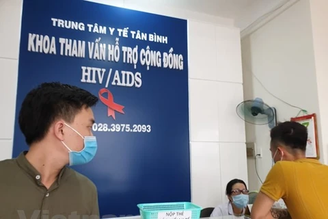 Nhân viên y tế hỗ trợ cho người dân đến tư vấn tại Trung tâm y tế quận Tân Bình, Thành phố Hồ Chí Minh. (Ảnh: T.G/Vietnam+)