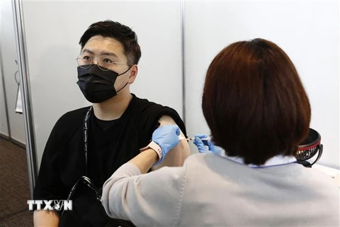 Nhân viên y tế tiêm vaccine phòng COVID-19 cho người dân tại Tokyo, Nhật Bản ngày 25/6/2021. (Ảnh: AFP/TTXVN)