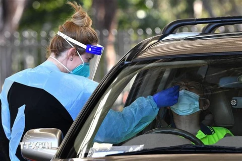 Nhân viên y tế lấy mẫu xét nghiệm COVID-19 cho người dân tại Sydney, Australia ngày 28/7/2021. (Ảnh: AFP/TTXVN)