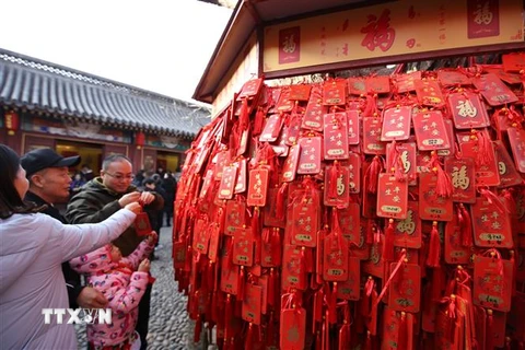Người dân cầu nguyện những điều tốt đẹp cho năm mới tại Thanh Đảo, tỉnh Sơn Đông, Trung Quốc. (Ảnh: THX/TTXVN)