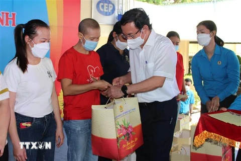 Bí thư Thành ủy TP Hồ Chí Minh Nguyễn Văn Nên tặng quà công nhân khó khăn ở Đồng Nai. (Ảnh: Công Phong/TTXVN)