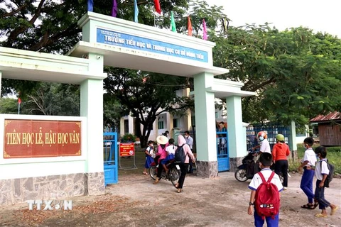 Học sinh trường Tiểu học và Trung học cơ sở Đông Tiến (xã Đông Tiến) đến trường. (Ảnh: Nguyễn Thanh/TTXVN)