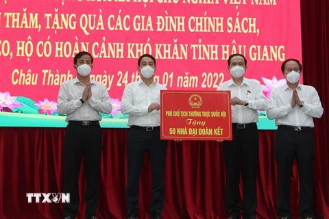 Ông Trần Thanh Mẫn (thứ 2 từ phải qua), Ủy viên Bộ Chính trị, Phó Chủ tịch Thường trực Quốc hội trao bảng tượng trưng nhà Đại đoàn kết. (Ảnh: Hồng Thái/TTXVN)