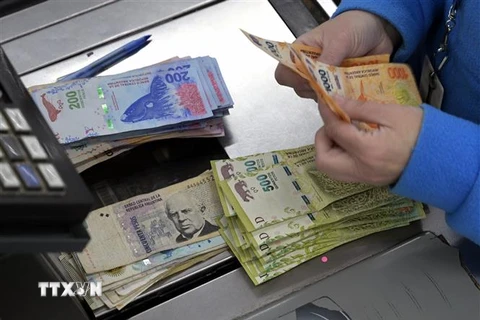 Kiểm đồng peso của Argentina tại một siêu thị ở Buenos Aires, ngày 15/8/2021. (Ảnh: AFP/TTXVN)