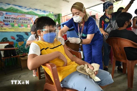 Nhân viên y tế tiêm vaccine phòng COVID-19 cho trẻ em tại Taguig, Philippines. (Ảnh: AFP/TTXVN)
