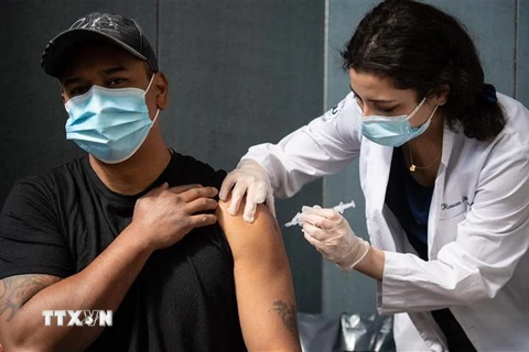 Nhân viên y tế tiêm vaccine phòng COVID-19 cho người dân tại New York, Mỹ. (Ảnh: AFP/TTXVN)