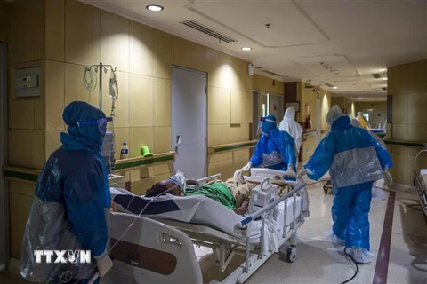 Nhân viên y tế chuyển bệnh nhân COVID-19 tại bệnh viện ở Surabaya, Đông Java, Indonesia. (Ảnh: AFP/TTXVN)