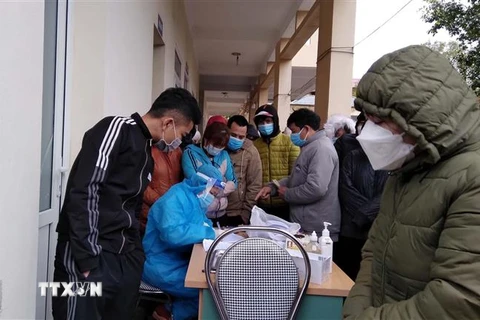Công nhân chen nhau lấy mẫu xét nghiệm tại Trạm y tế phường Bình Minh, thị xã Nghi Sơn (Thanh Hóa). (Ảnh: Nguyễn Nam/TTXVN)