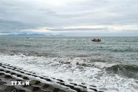 Lực lượng biên phòng đang tìm kiếm người mất tích trong vụ chìm canô du lịch tại Cửa Đại. (Ảnh: TTXVN)