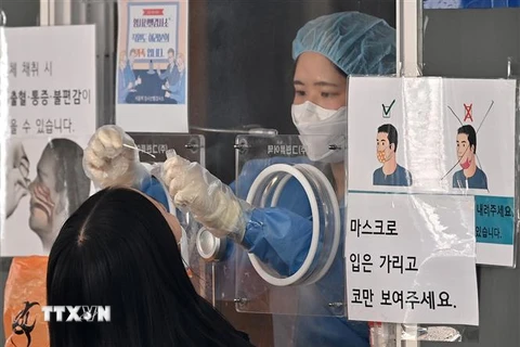 Nhân viên y tế lấy mẫu xét nghiệm COVID-19 cho người dân tại Seoul, Hàn Quốc, ngày 4/3/2022. (Ảnh: AFP/TTXVN)