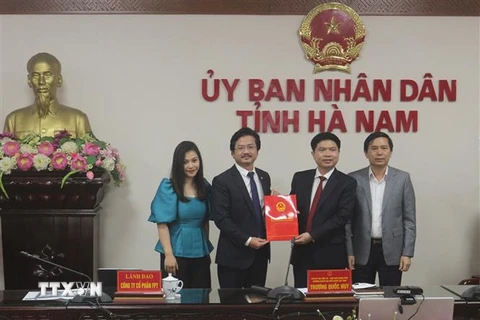 Chủ tịch UBND tỉnh Hà Nam Trương Quốc Huy trao giấy chứng nhận đăng ký đầu tư Dự án đầu tư xây dựng cơ sở giáo dục và đào tạo cho đại điện tập đoàn FPT. (Ảnh: Thanh Tuấn/TTXVN)