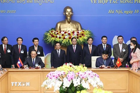 Thủ tướng Phạm Minh Chính và Thủ tướng Lào Phankham Viphavanh chứng kiến Lễ ký kết thoả thuận về Kế hoạch hợp tác Việt Nam-Lào năm 2022. (Ảnh: Dương Giang/TTXVN)