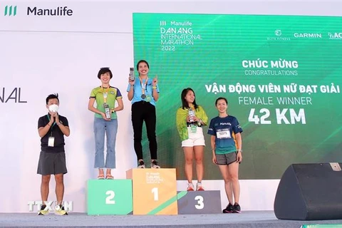 Ban Tổ chức trao giải cho các vận động viên đoạt giải cự ly 42km nữ. (Ảnh: TTXVN phát)