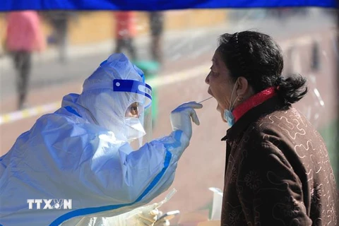  Nhân viên y tế lấy mẫu xét nghiệm COVID-19 cho người dân tại Thẩm Dương, tỉnh Liêu Ninh, Trung Quốc, ngày 17/3/2022. (Ảnh: THX/TTXVN)