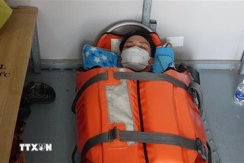 Thuyền viên Ngô Tấn Lộc bị nạn trên biển được cấp cứu trên tàu SAR 421 và đưa về bờ. (Ảnh: TTXVN phát)