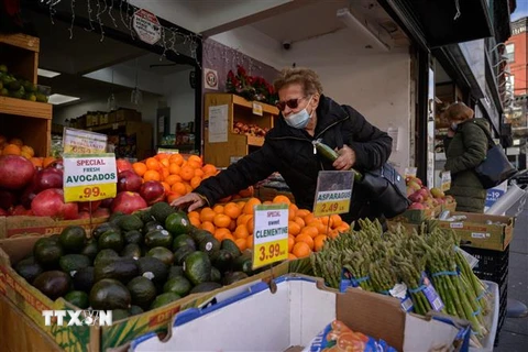 Khách hàng chọn mua hàng tại một quầy bán hoa quả ở New York, Mỹ. (Ảnh: AFP/TTXVN)