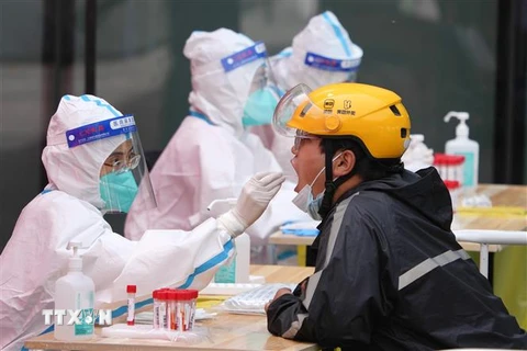 Nhân viên y tế lấy mẫu xét nghiệm COVID-19 cho người dân tại Bắc Kinh, Trung Quốc ngày 5/5/2022. (Ảnh: THX/TTXVN)