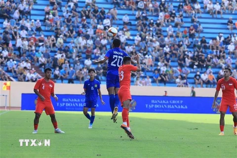 Tiền đạo đội trưởng U23 Lào Ekkamai (20) tranh chấp bóng bổng với hậu vệ Syahrul bin Sazaly (13, U23 Singapore). (Ảnh: Tuấn Anh/TTXVN)
