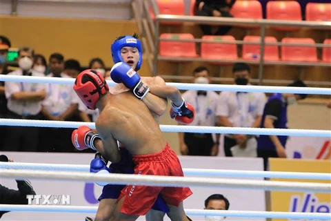 VĐV Nguyễn Quang Huy của đội Kickboxing Việt Nam (xanh) thắng VĐV Chhut Vannthong của đội Campuchia (đỏ) với tỷ số 3-0. (Ảnh: Đinh Văn Nhiều/TTXVN)