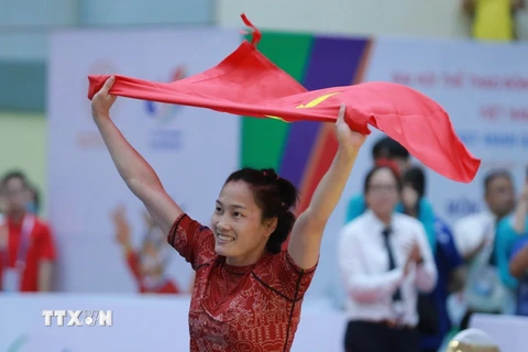 Niềm vui sướng của VĐV Phùng Thị Huệ khi giành huy chương vàng đầu tiên môn Jujitsu cho đoàn Việt Nam. (Ảnh: Hoàng Hiếu/TTXVN)