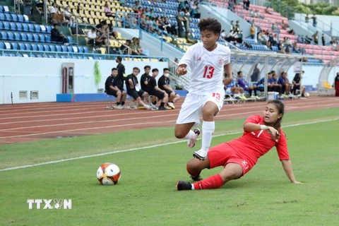 Cầu thủ Pont Pont Pyae Maung đội tuyển nữ Myanmar đẩy đi bóng qua sự truy cản của cầu thủ Putri Nur Syaliza Binte Sazali đội tuyển nữ Singapore. (Ảnh: Anh Tuấn/TTXVN)