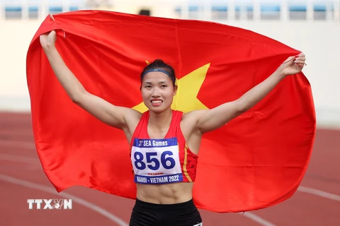 Niềm vui của VĐV Nguyễn Linh Na bên lá quốc kỳ Việt Nam khi giành Huy chương Vàng SEA Games 31. (Ảnh: Quốc Khánh/TTXVN)