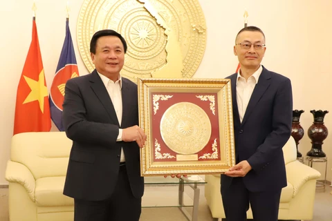 Đồng chí Nguyễn Xuân Thắng tặng quà lưu niệm cho Đại sứ Vũ Quang Minh. (Ảnh: Mạnh Hùng/TTXVN)