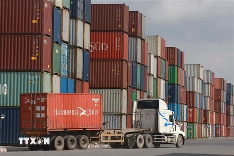 Bốc xếp container hàng hóa tại Tân cảng Cát Lái. (Ảnh: Quang Châu/TTXVN)