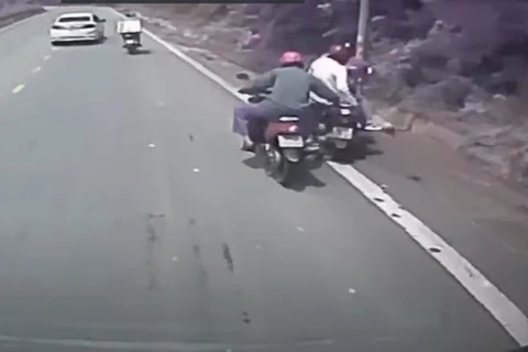 Anh Đinh Văn Chiến dũng cảm kéo xe máy bị mất phanh trên đường đèo Tam Đảo. (Ảnh cắt từ clip) 