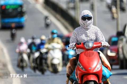 Người tham gia giao thông cần trang bị khẩu trang, áo chống nắng che kín người tránh tình trạng sốc nhiệt vì nắng nóng. (Ảnh: Thành Đạt/TTXVN)