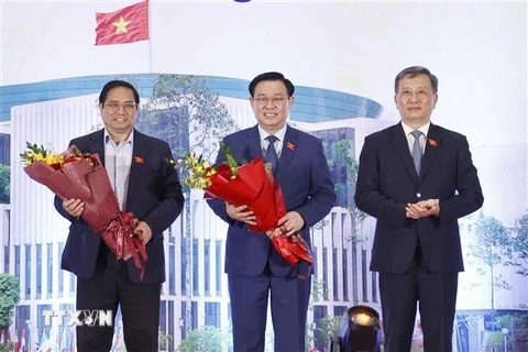 Chủ nhiệm Ủy ban Khoa học Công nghệ Môi trường của Quốc hội Lê Quang Huy đại diện cho các đại biểu Quốc hội khoá XV là nhà khoa học tặng hoa Thủ tướng Phạm Minh Chính và Chủ tịch Quốc hội Vương Đình Huệ. (Ảnh: Doãn Tấn/TTXVN)