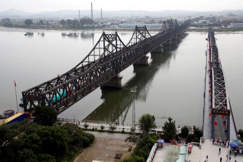 Xe tải chở hàng hóa đi qua cầu Hữu nghị (trái) từ Đan Đông, Trung Quốc, đến thành phố Sinuiju, Triều Tiên. Ảnh minh họa. (Nguồn: Reuters)